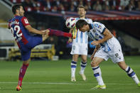 Barcelona's Ilkay Gundogan, left and Real Sociedad's Robin Le Normand challenge for the ball with Le Normand getting kicked in the head during a Spanish La Liga soccer match between Barcelona and Real Sociedad at the Olimpic Lluis Companys stadium in Barcelona, Spain, Monday, May 13, 2024. (AP Photo/Joan Monfort)