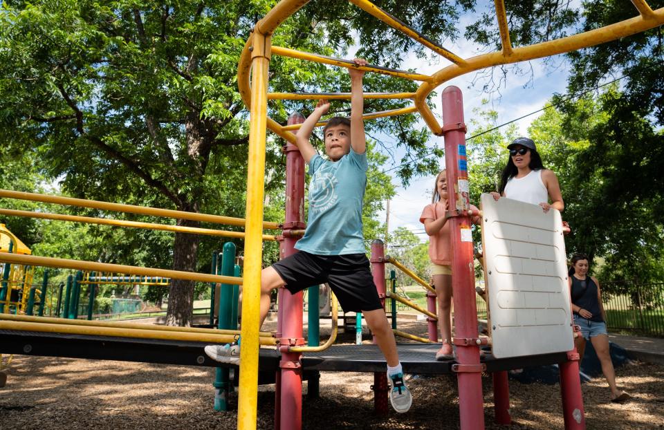 Logan Zeiher, 7, navigates the monkey bars at Zilker Park while his younger sister, Olivia, 5, watches. Kids need to be at a moderate to vigorous physically active level for at least 60 minutes a day, experts say.