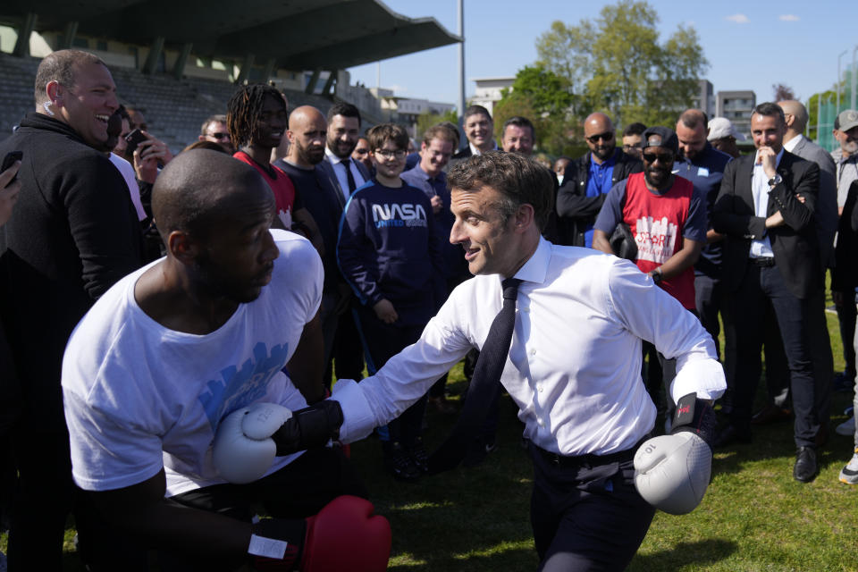 FILE - Centrist presidential candidate and French President Emmanuel Macron trains at boxing with amateur boxer Jean-Denis Nzaramba in the Auguste Delaune stadium as he campaigns in the Auguste Delaune stadium Thursday, April 21, 2022 in Saint-Denis, outside Paris. (AP Photo/Francois Mori, Pool, File)