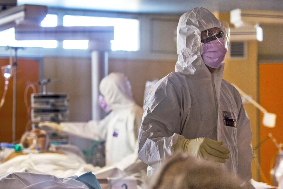 FILE - In this March 25, 2020 file photo, medical staff tend to patients at the intensive care unit of the Casalpalocco COVID-19 Clinic on the outskirts of Rome. The pressures on intensive care units in Italy and Spain may have eased in recent days as new coronavirus cases decline, but the psychological toll the pandemic has taken on the doctors and nurses who work there is only now beginning to emerge. (AP Photo/Domenico Stinellis, File)