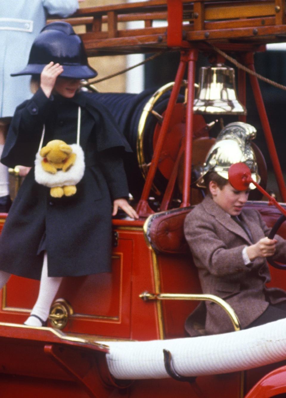 A young Zara Phillips and Prince William climb on a car at Sandringham