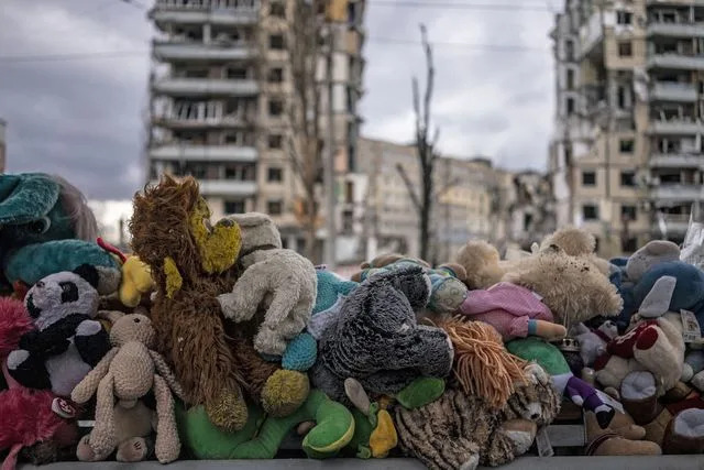 Jose Colon/Anadolu Agency via Getty Toys are piled outside a residential building in Dnipro, Ukraine, that was bombed by a Russian rocket in 2023, killing at least 46 people and injuring 80 more