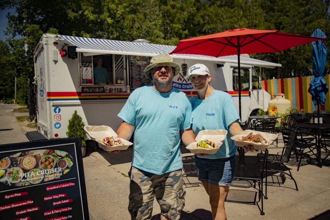 Blake and Jami Miller pose in front of their previous Greek food truck. The pair opened the Pita Cruiser restaurant in downtown Charlevoix on April 26.