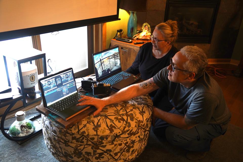 Christine and John Moczynski of West Bend work in their living room on displays from cameras providing video of a great-horned owl nesting in a flower pot on their 4th floor balcony.