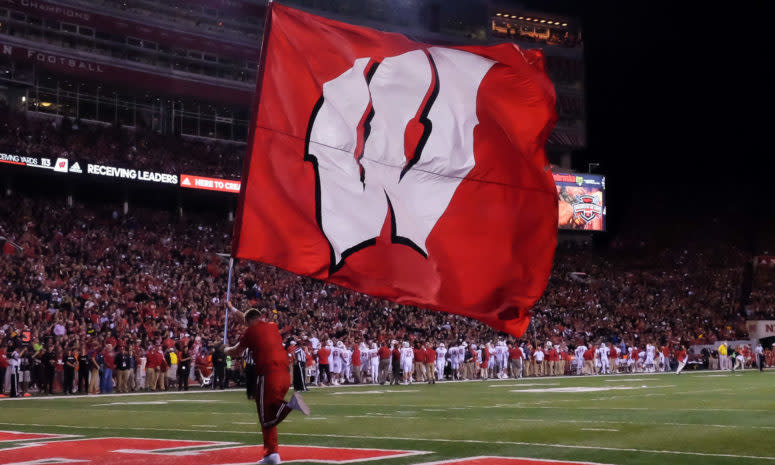 Wisconsin flag bearer runs across the field.