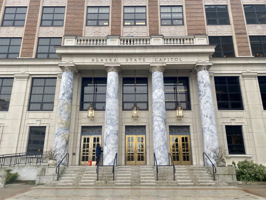 A maintenance worker cleans the front of the Alaska State Capitol in Juneau on April 2, 2024. (Photo by Claire Stremple/Alaska Beacon)