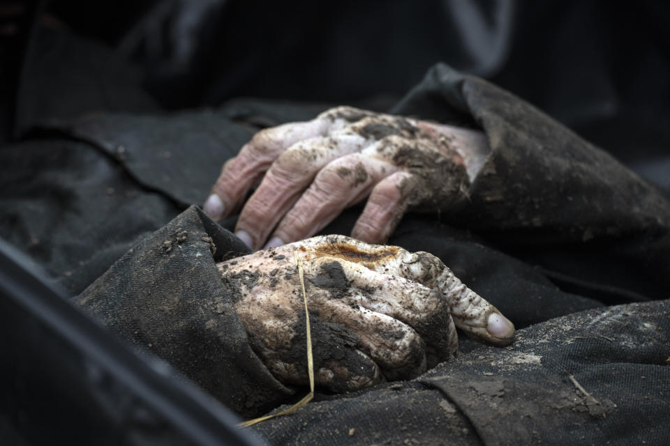 FILE -A view of the corpse of a civilian killed, before being transported to the morgue, in the cemetery in Bucha, on the outskirts of Kyiv, Ukraine, Wednesday, April 6, 2022. Two former German government ministers have submitted a criminal complaint with federal prosecutors seeking the opening of a war crimes probe against Russian officials over the conflict in Ukraine. (AP Photo/Rodrigo Abd,file)