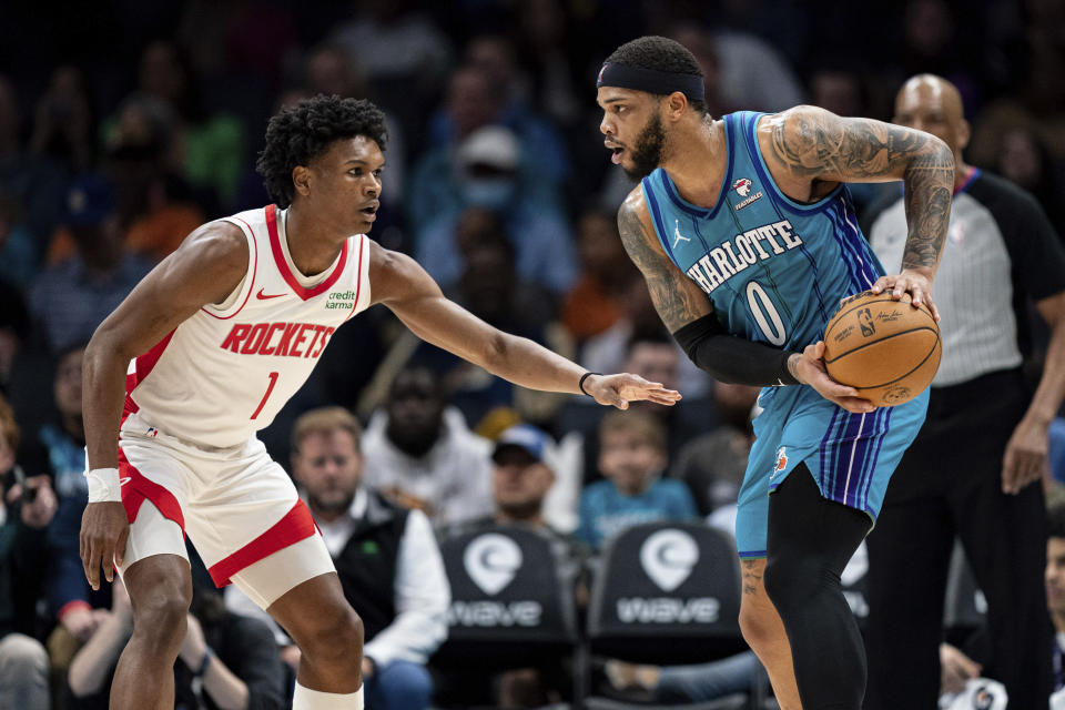 Houston Rockets forward Amen Thompson (1) guards Charlotte Hornets forward Miles Bridges (0) during the first half of an NBA basketball game Friday, Jan. 26, 2024 in Charlotte, N.C. (AP Photo/Jacob Kupferman)