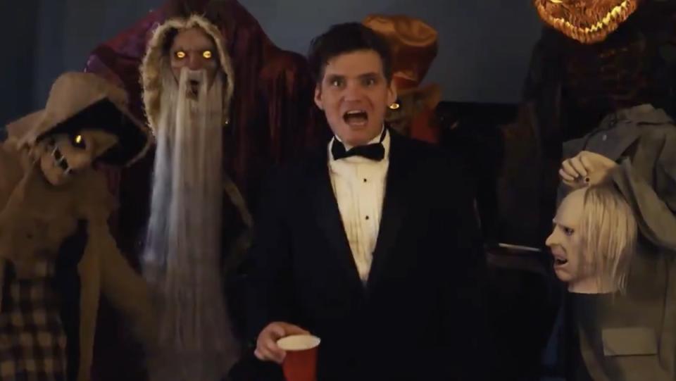 Nick Lutsko in a tuxedo surrounded by animatronics from Spirit Halloween from the video for "Unleash Your Spirit"