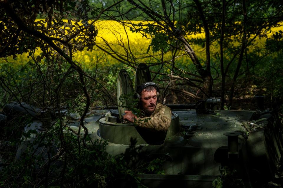 A Ukrainian soldier from the 57th Brigade waits for an order for his artillery vehicle to open fire on Russian positions at the front line in Ukraine’s Kharkiv region (AP)