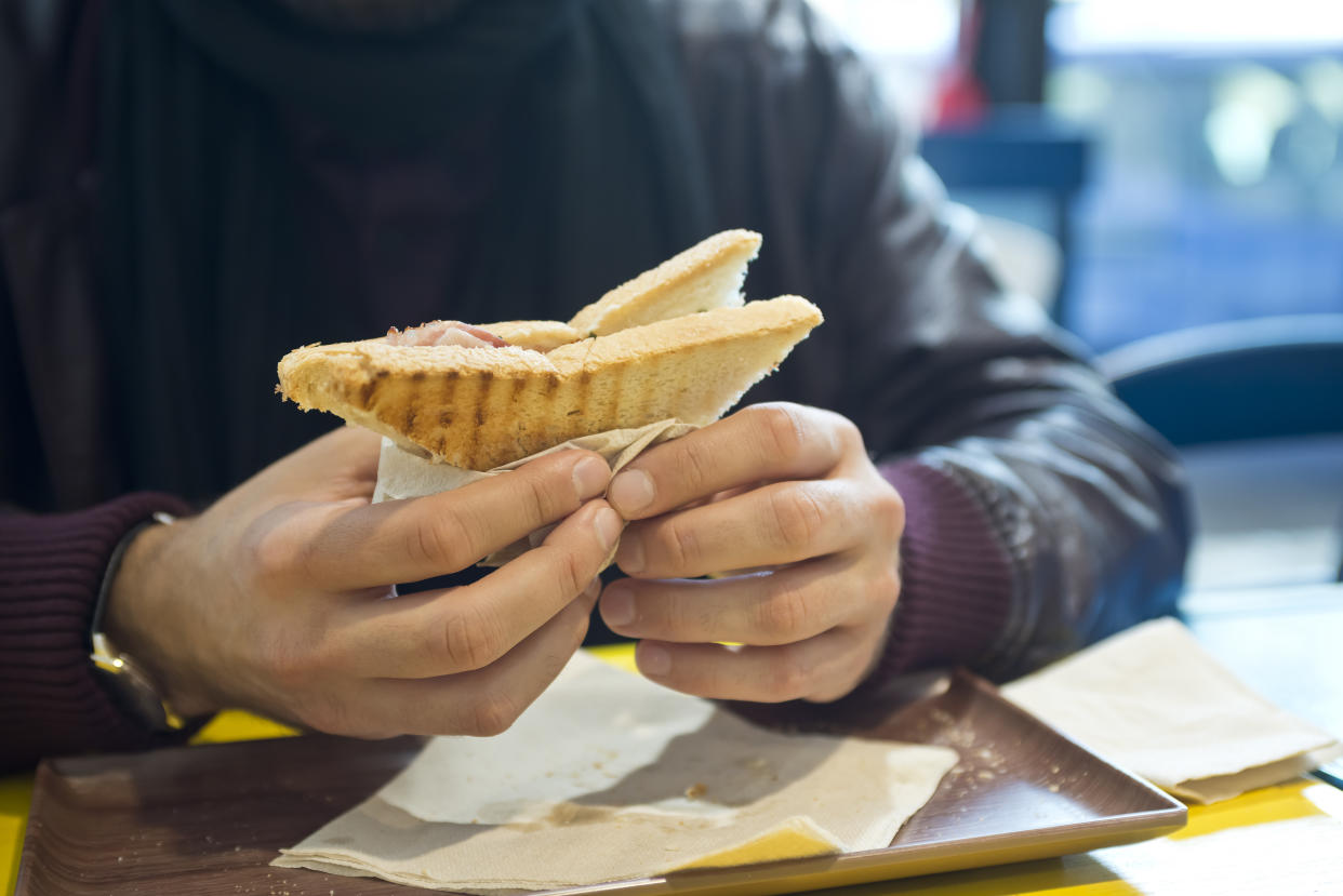 Man eating fast food, mid section, close-up