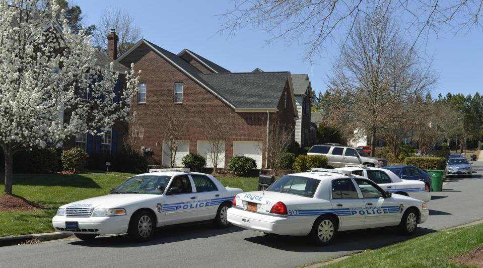 Charlotte-Mecklenburg Police Department cars sit outside Charlotte Mayor Patrick Cannon's home as federal agents search the house, Wednesday, March 26, 2014, in Charlotte, N.C. A city spokesman says Cannon has resigned effective immediately, just hours after he was charged with federal public corruption and bribery. (AP Photo/The Charlotte Observer, Davie Hinshaw)