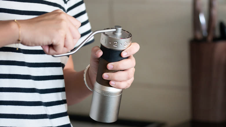 Person using a coffee grinder