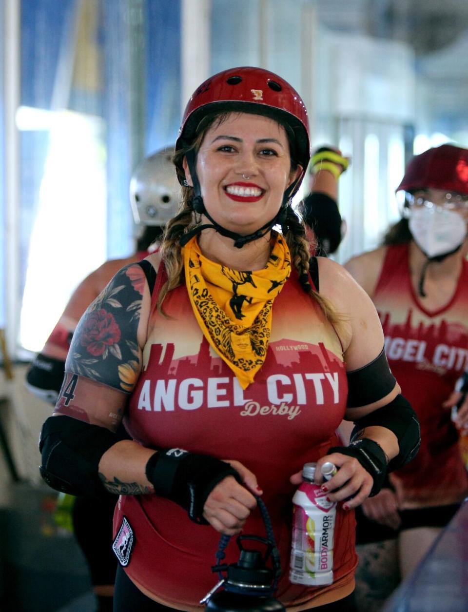 Mujer sonriente con casco con coderas y muñequeras