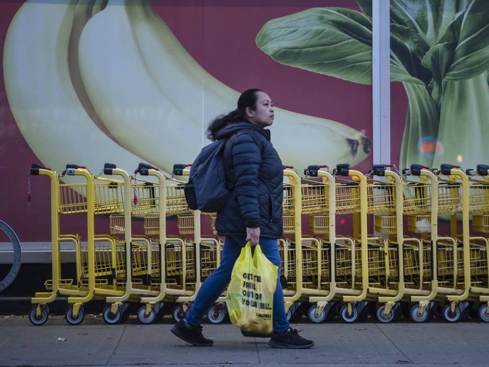  A pedestrian walks past No Frills food murals on Bloor Street in Toronto.