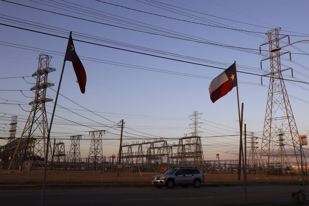 Texas flags fly near an electrical substation on February 21, 2021 in Houston, Texas. Millions of Texans lost their power when winter storm Uri hit the state and knocked out coal, natural gas and nuclear plants that were unprepared for the freezing temperatures brought on by the storm. Wind turbines that provide an estimated 24 percent of energy to the state became inoperable when they froze. (Photo by Justin Sullivan/Getty Images)