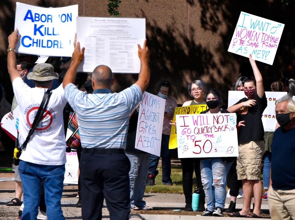 Demonstrators on both side of the abortion debate wave their signs in each others' direction before the Rally for Abortion Justice outside the Taylor County Courthouse Oct. 2. The gathering preceded the Abilene Women's March through downtown.