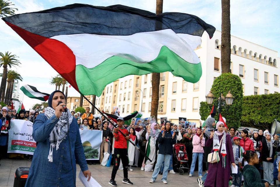 A young man waves a huge Palestinian flag in support of the Palestinian people in the Israeli occupied West Bank and the Gaza Strip, during a rally in Rabat.