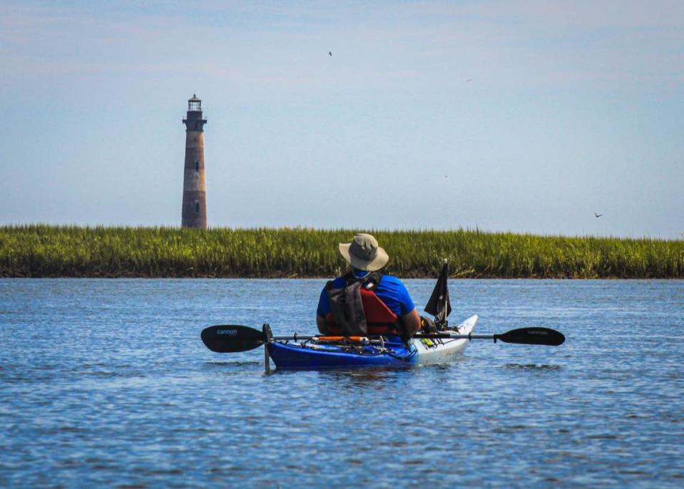 Paddle to the lighthouse: the Morris Island Lighthouse is still a beacon for boats large and small. Here it guides kayaker Tim Brown of Savannah down Folly Creek for a closer look.