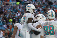 Miami Dolphins wide receiver Jaylen Waddle (17) is lifted by teammate Robert Hunt after scoring a touchdown during the first half of an NFL football game against the Carolina Panthers, Sunday, Nov. 28, 2021, in Miami Gardens, Fla. (AP Photo/Lynne Sladky)