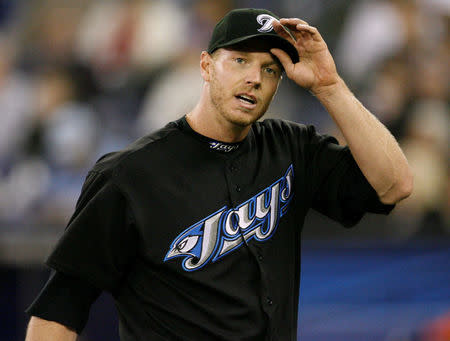 FILE PHOTO: Toronto Blue Jays starting pitcher Roy Halladay adjusts his cap while walking off the field against the Chicago White Sox during the fourth inning of their MLB American League baseball game in Toronto, May 4, 2008. REUTERS/ Mike Cassese/File Photo