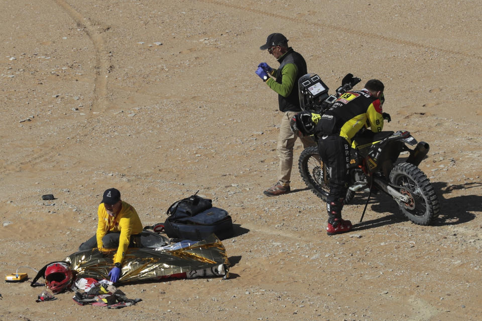 The body of Paulo Gonçalves of Portugal is covered with a blanket after a deadly fall during stage seven of the Dakar Rally between Riyadh and Wadi Al Dawasir, Saudi Arabia, on Jan. 12, 2020. Gonçalves, 40, died after an accident with his Hero motorbike. (AP Photo/Bernat Armangue)