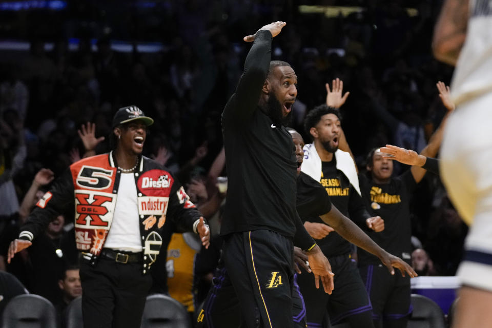 Los Angeles Lakers forward LeBron James, right, and other players celebrate after center Jaxson Hayes (11) dunked during the second half of an NBA basketball in-season tournament game against the Memphis Grizzlies in Los Angeles, Tuesday, Nov. 14, 2023. (AP Photo/Ashley Landis)