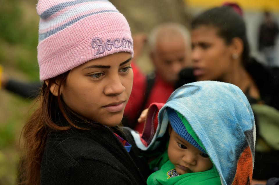 <p>A Venezuelan woman and her baby wait in line to cross to Ecuador at the Rumichaca international bridge in Ipiales, Colombia, on Aug. 11, 2018. (Photo: Rodrigo Buendia/AFP/Getty Images) </p>