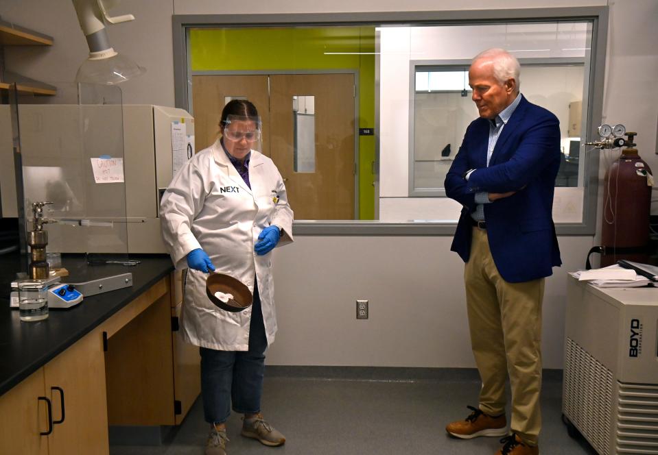 Alli Mae Berry, a research chemist at Abilene Christian University’s  Nuclear Energy eXperimental Testing Lab, demonstrates to U.S. Sen. John Cornyn on Tuesday the safety differences between a leak in a traditional water-cooled nuclear reactor versus a leak in a molten salt-cooled reactor like the kind to be installed at ACU. Kept in a liquid form by extreme heat, molten salt would cool into a solid if it leaked from its containment, unlike pressurized water which can vent into the atmosphere and spread, Berry explained.