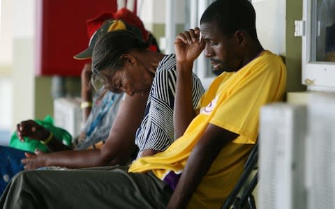 Mary Naryfrank (C) and her son Lathalie Johl (R) sit at a shelter in the Sir Vivian Richards Cricket Stadium - Credit: Jose Jimenez/Getty Images