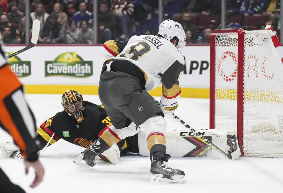 Vegas Golden Knights' Phil Kessel, front, scores against Vancouver Canucks goalie Thatcher Demko during the first period of an NHL hockey game Tuesday, March 21, 2023, in Vancouver, British Columbia. (Darryl Dyck/The Canadian Press via AP)