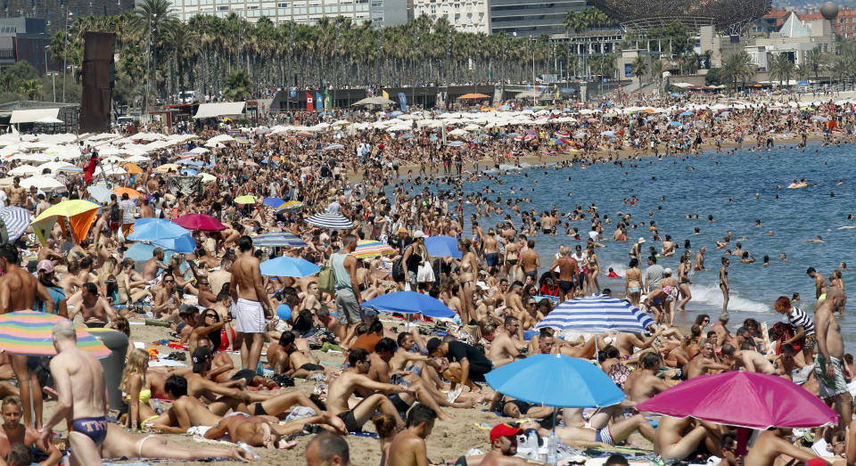 People cool off at Sant Sebastia beach in Barceloneta neighbourhood in Barcelona, Spain, August 16, 2015. Spanish consumer prices rose slightly in July from a year earlier, the second increase in a row as the economy strengthened and retailers and hotels hiked their charges. The prices of package holidays were up from a year ago in July, National Statistics Institute (INE) said. Hotel, cafe and restaurant prices were up 0.9 percent year-on-year in July when the summer tourism season got underway. REUTERS/Albert Gea      TPX IMAGES OF THE DAY     