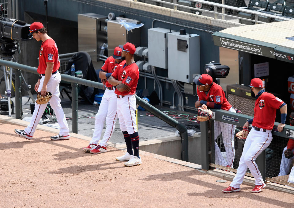 Twins players wait patiently for a drone to complete its mission. (Hannah Foslien/Getty Images)