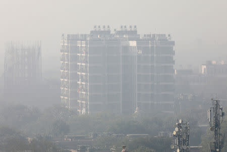 FILE PHOTO: A residential building is shrouded in smog in New Delhi, India, December 25, 2018. REUTERS/Altaf Hussain