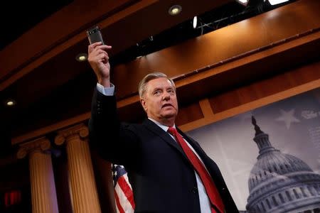 Senator Lindsey Graham (R-SC) holds up his cell phone during a press conference about his resistance to the so-called "Skinny Repeal" of the Affordable Care Act on Capitol Hill in Washington, U.S., July 27, 2017. REUTERS/Aaron P. Bernstein