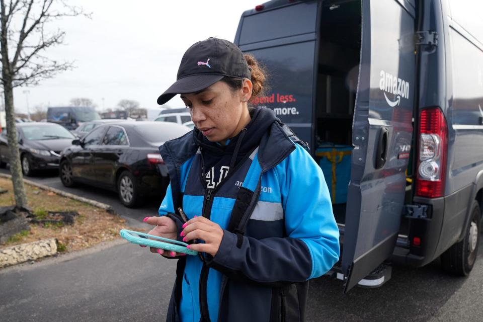 Amazon driver Lynnette Rivera checks her work phone to see where her deliveries will be so she can map out her route before hitting the road for the day.