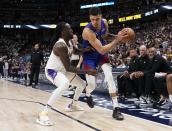 Denver Nuggets forward Michael Porter Jr., center right, is pressured by Los Angeles Lakers forward Taurean Prince, center left, during the second half in Game 1 of an NBA basketball first-round playoff series Saturday, April 20, 2024, in Denver. (AP Photo/Jack Dempsey)