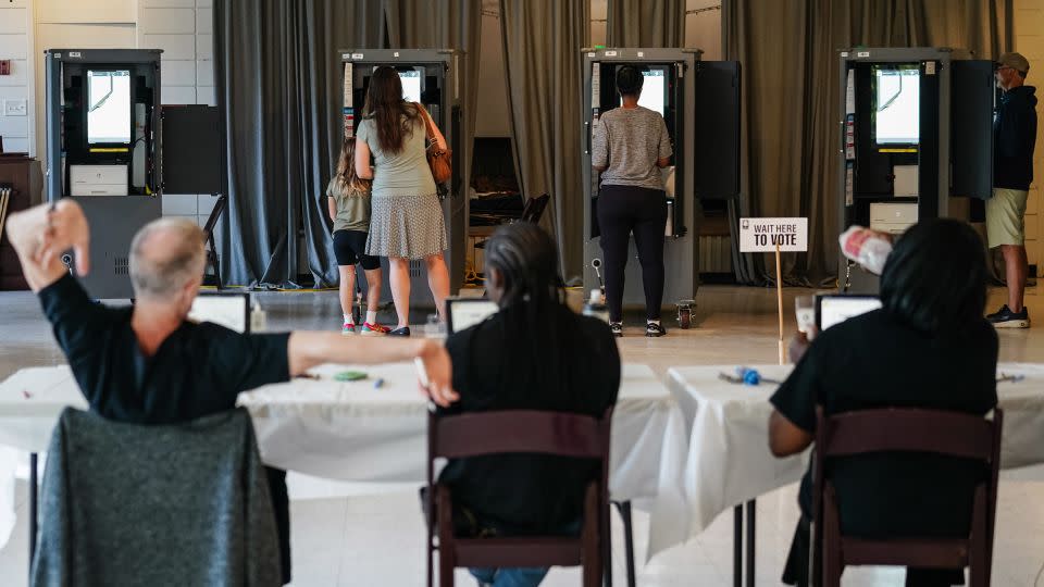 A Fulton County Elections worker stretches his arms as voters cast ballots in Georgia's primary election at a polling location in Atlanta on May 21, 2024. - Elijah Nouvelage/Getty Images/File