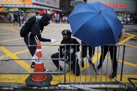 Anti-government demonstrators build a barricade during protest against the invocation of the emergency laws in Hong Kong