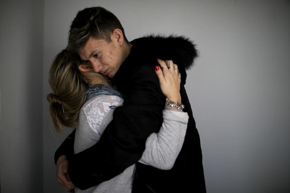 In this Aug. 1, 2019 photo, Ezequiel Villalonga, one of about 20 ex-students from the Antonio Próvalo School for Deaf and Hearing Impaired Children who say they were sexually abused by two Roman Catholic priests, including cases of rape, hugs his mother in Mendoza, Argentina. Villalonga's alleged abuser goes on trial starting Monday, Aug. 5, 2019. (AP Photo/Natacha Pisarenko)