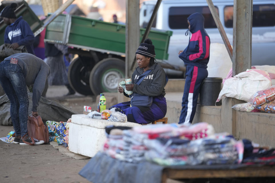 A vendor counts her money after making a sale in Harare, Thursday ,June, 2, 2022. Rampant inflation is making it increasingly difficult for people in Zimbabwe to make ends meet. Since the start of Russia’s war in Ukraine, official statistics show that Zimbabwe’s inflation rate has shot up from 66% to more than 130%. The country's finance minister says the impact of the Ukraine war is heaping problems on the already fragile economy. (AP Photo/Tsvangirayi Mukwazhi)