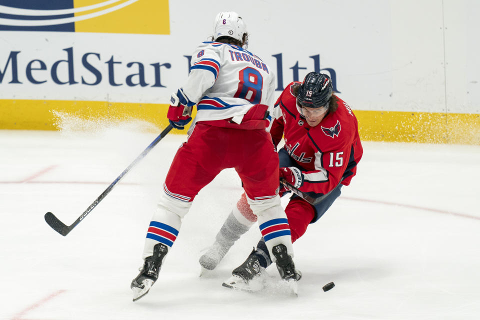 New York Rangers defenseman Jacob Trouba (8) collides with Washington Capitals left wing Sonny Milano (15) while battling for control of the puck during the third period of an NHL hockey game, Saturday, Dec. 9, 2023, in Washington. (AP Photo/Stephanie Scarbrough)