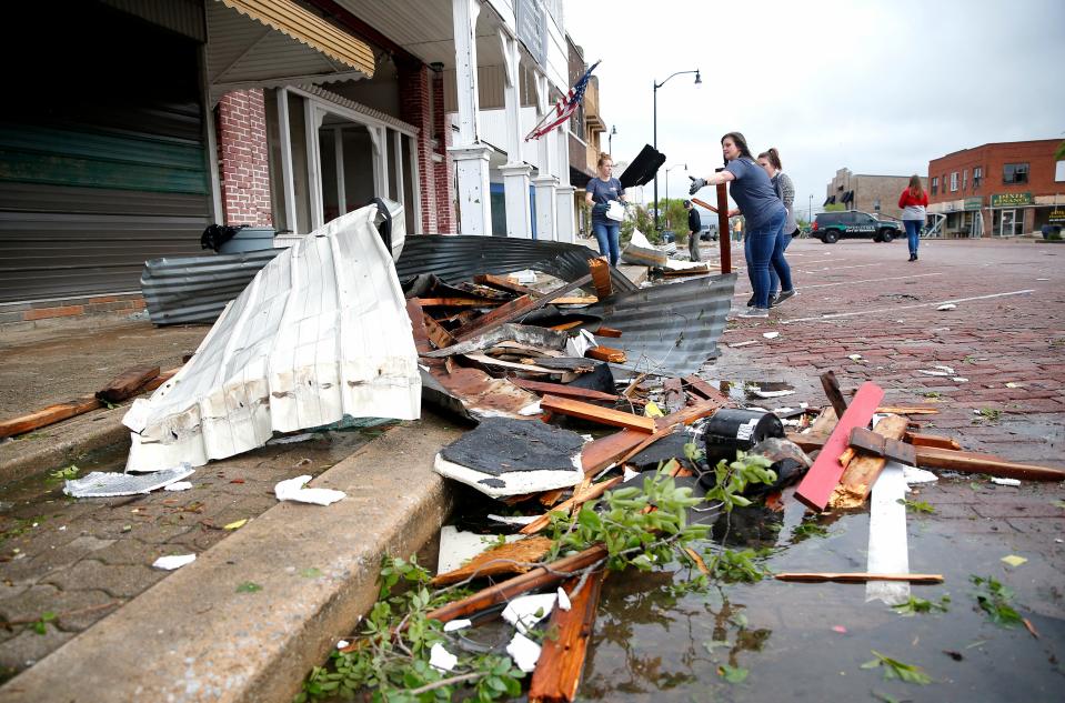 People clean up damage in downtown Seminole on May 5 after tornadoes moved through the area the prior night. FEMA officials have since declared the area eligible for disaster assistance.
