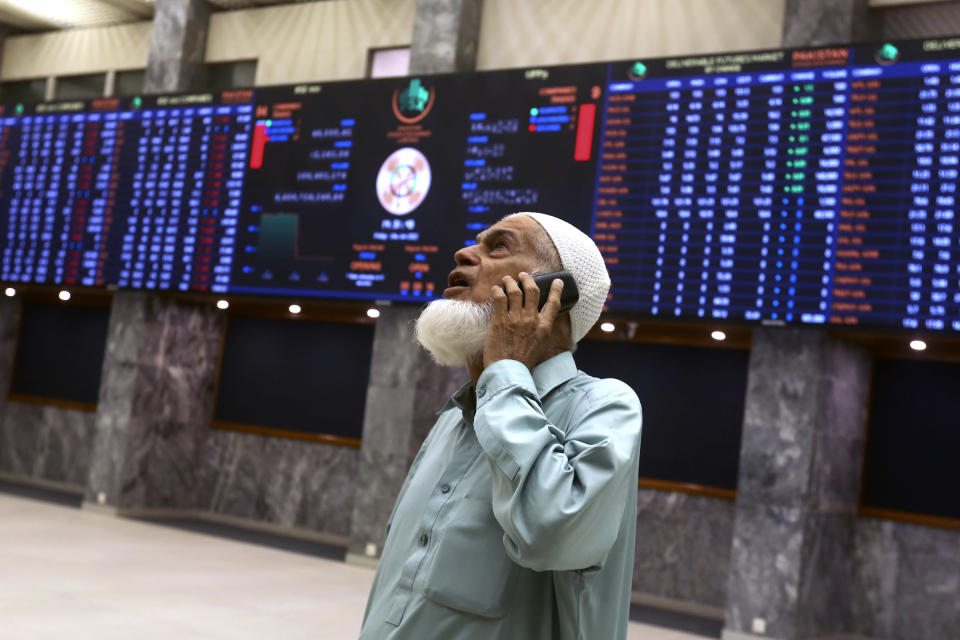 FILE - An investor monitors indexes on the big screen at the Pakistan Stock Exchange (PSE), in Karachi, Pakistan, Friday, June 24, 2022. Some 1.6 billion people in 94 countries face at least one dimension of the crisis in food, energy and financial systems, according to a report last month by the Global Crisis Response Group of the United Nations Secretary-General. (AP Photo/Fareed Khan, File)