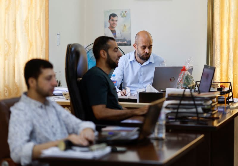Palestinians employees work at Gaza government media office, in Gaza City