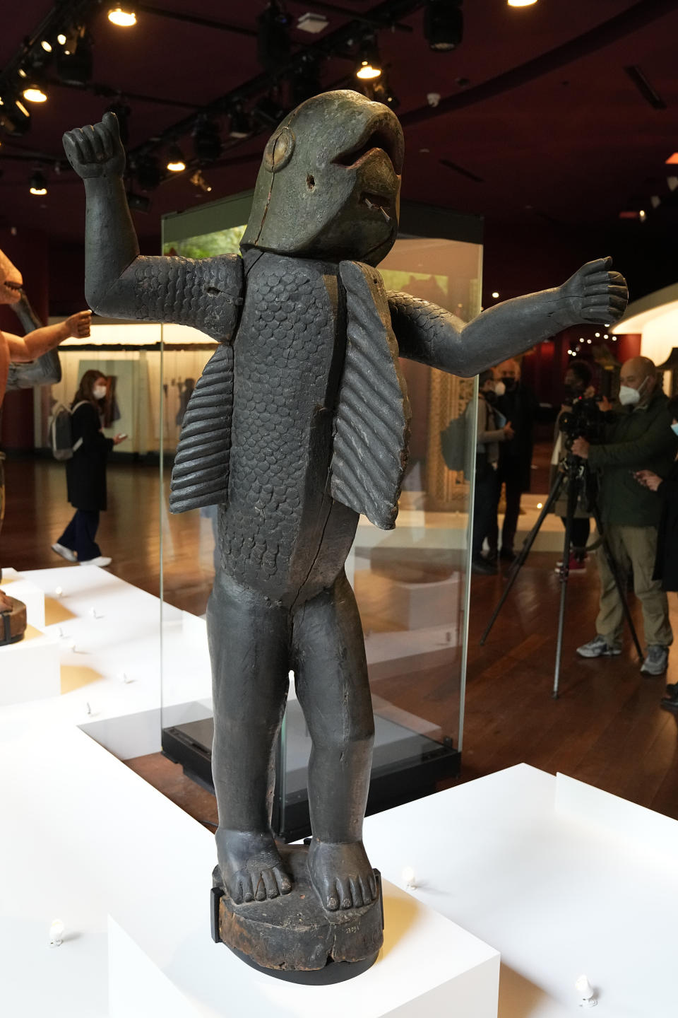 The royal statue half-man, half-shark of Benin's 19th century King Behanzin is pictured at the Quai Branly–Jacques Chirac museum, Monday, Oct. 25, 2021 in Paris. In a decision with potential ramifications across European museums, France is displaying 26 looted colonial-era artifacts for one last time before returning them home to Benin. The wooden anthropomorphic statues, royal thrones and sacred altars were pilfered by the French army in the 19th century from Western Africa. (AP Photo/Michel Euler)