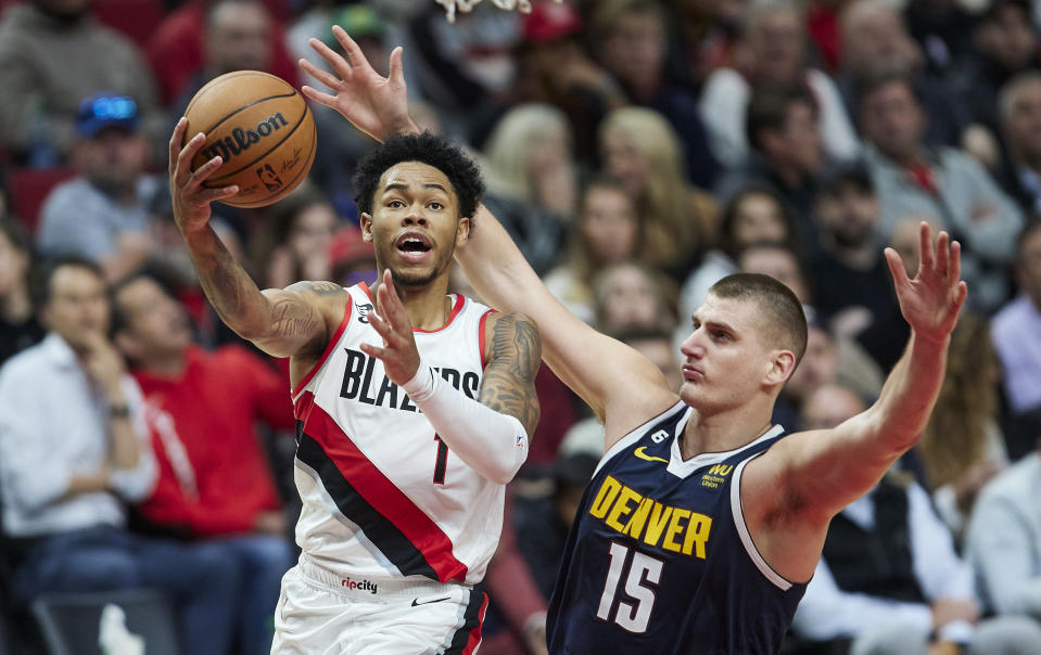 Portland Trail Blazers guard Anfernee Simons, left, shoots over Denver Nuggets center Nikola Jokic during the second half of an NBA basketball game in Portland, Ore., Monday, Oct. 24, 2022. (AP Photo/Craig Mitchelldyer)