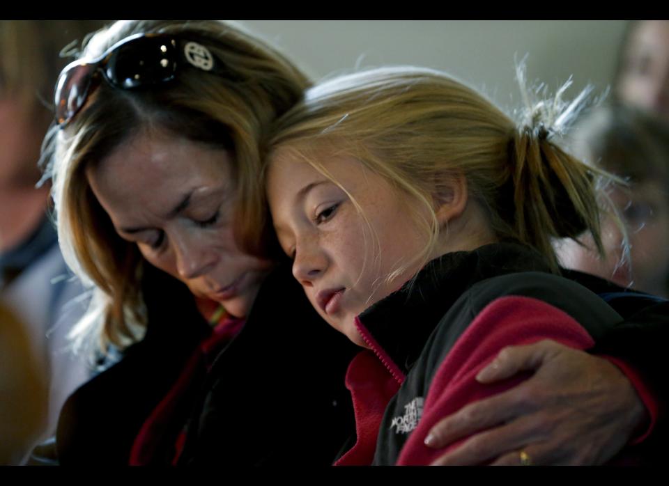 Molly Delaney, left, holds her 11-year-old daughter, Milly Delaney, during a service in honor of the victims who died a day earlier when a gunman opened fire at Sandy Hook Elementary School in Newtown, Conn., as people gathered at St. John's Episcopal Church , Saturday, Dec. 15, 2012, in the Sandy Hook village of Newtown, Conn. The massacre of 26 children and adults at Sandy Hook Elementary school elicited horror and soul-searching around the world even as it raised more basic questions about why the gunman, 20-year-old Adam Lanza, would have been driven to such a crime and how he chose his victims. 