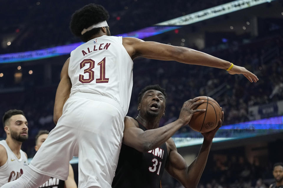 Miami Heat center Thomas Bryant, right, is fouled by Cleveland Cavaliers center Jarrett Allen during the first half of an NBA basketball game Wednesday, Nov. 22, 2023, in Cleveland. (AP Photo/Sue Ogrocki)