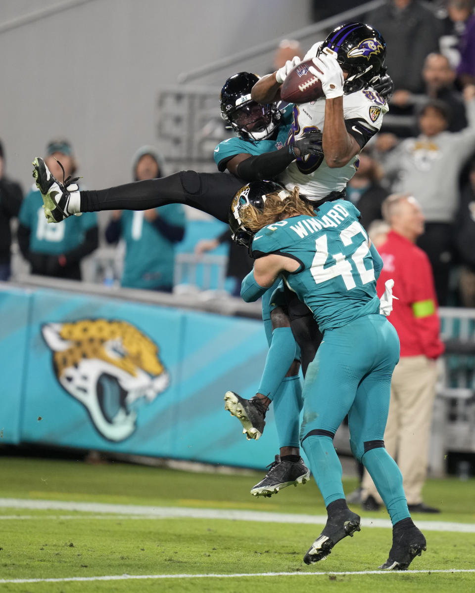 Baltimore Ravens tight end Isaiah Likely, top, makes a reception over Jacksonville Jaguars safety Andrew Wingard (42) in the second half of an NFL football game Sunday, Dec. 17, 2023, in Jacksonville, Fla. (AP Photo/John Raoux)